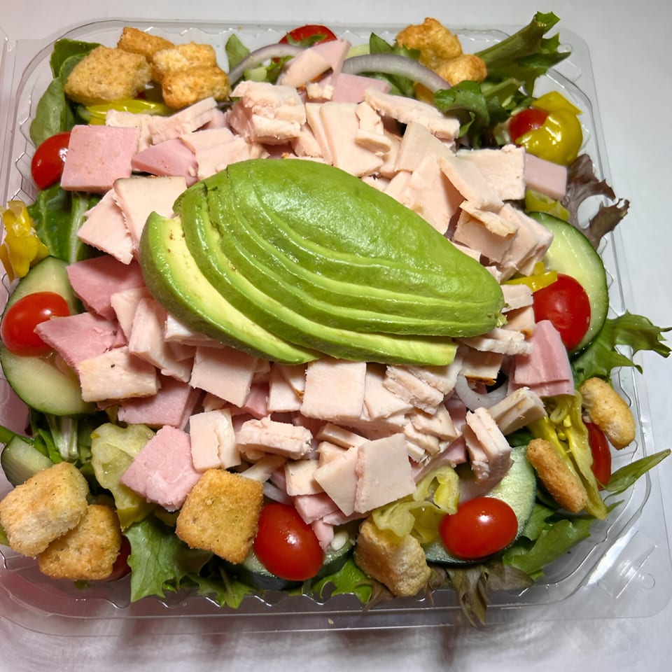 Baba's Deli Sub salad with sliced avocado, ham, turkey, croutons, tomatoes, cucumbers, and lettuce.