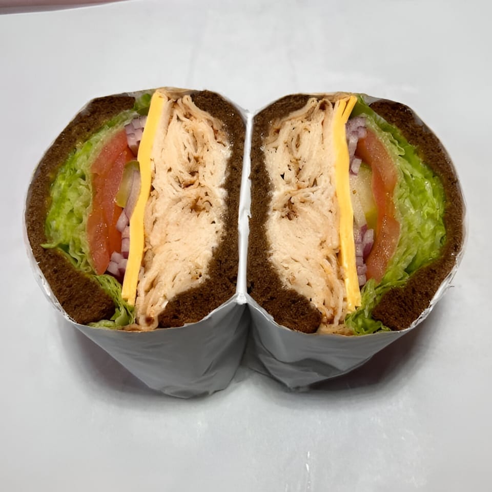 Baba's Deli Sub, a turkey sandwich on dark bread with lettuce, tomato, onion, and cheese.